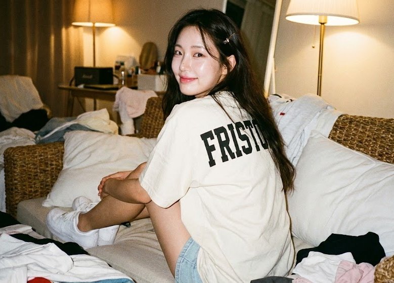 Preview of Girl Sitting with Her Back to the Audience on a Woven Sofa